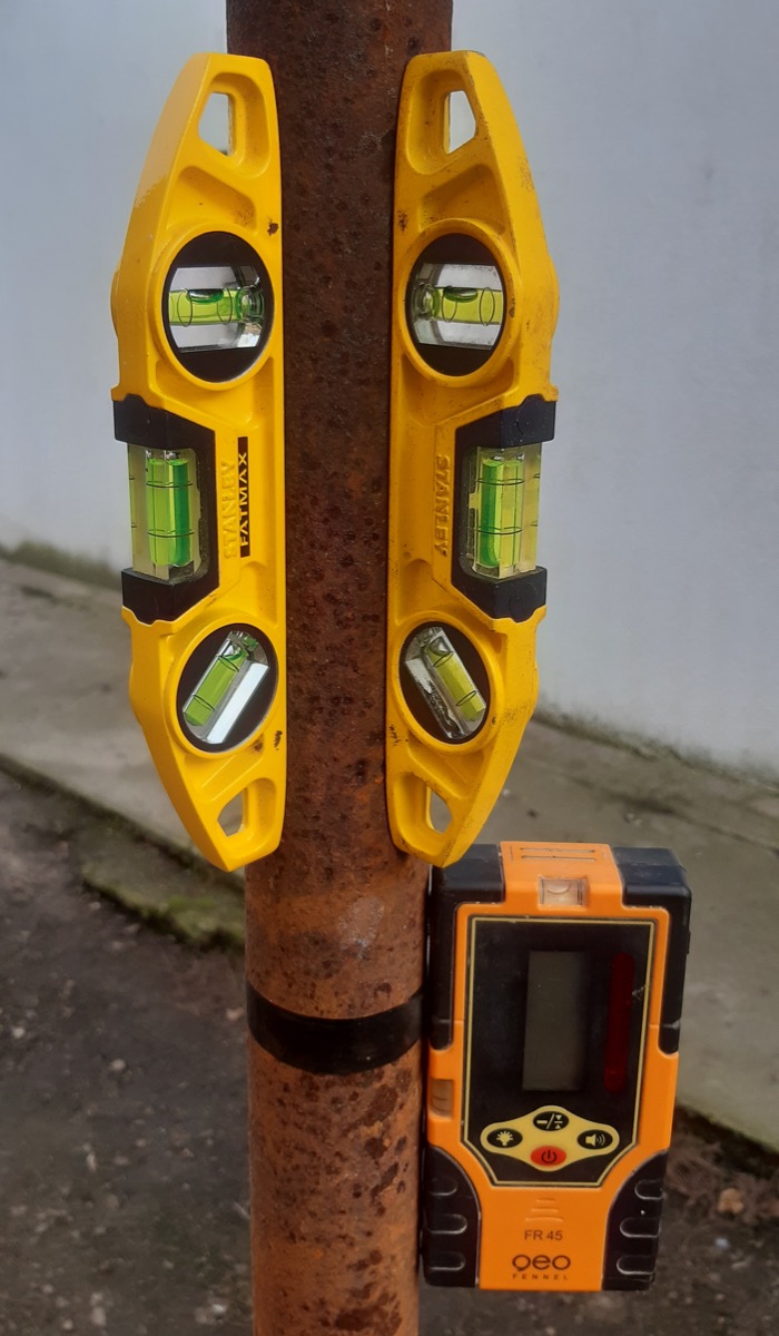 Magnetic spirit levels alongside a rotary laser level receiver showing professional leveling equipment