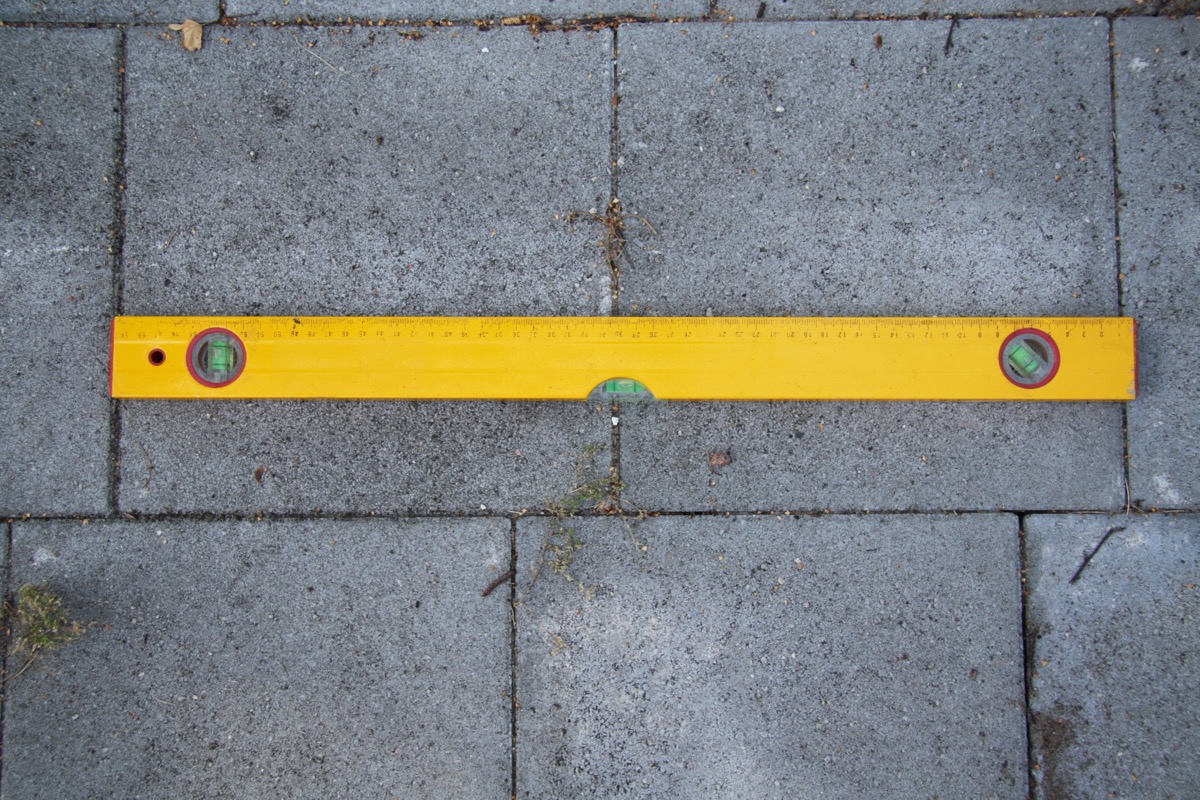 A spirit level tool being used to check the levelness of a surface