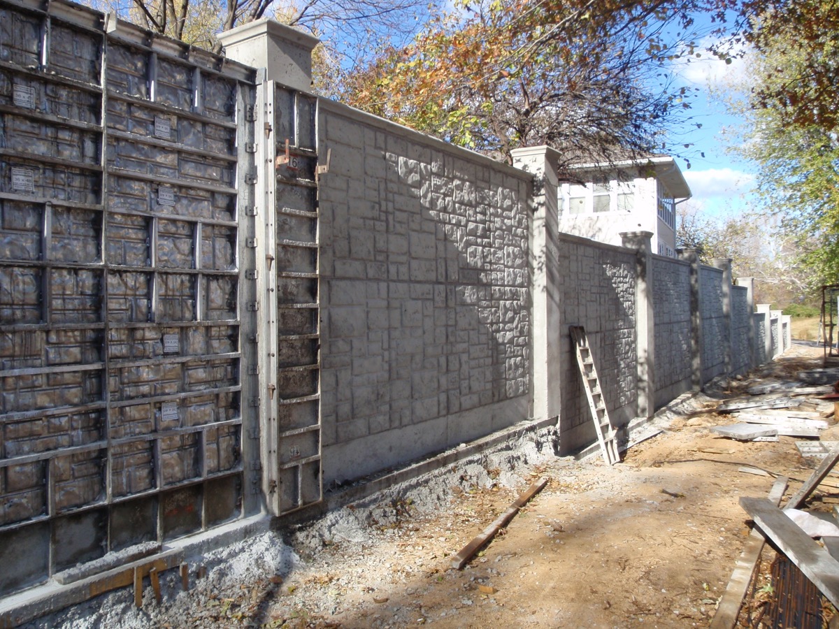 Concrete fence construction using formwork showing the post setting process